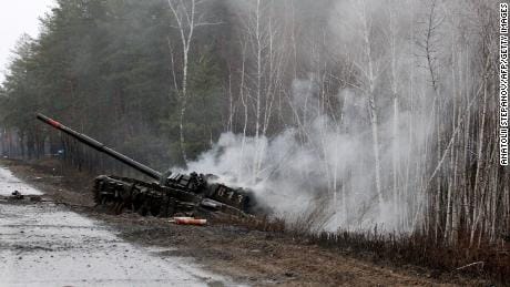 Smoke rises from a Russian tank destroyed by Ukrainian forces on the side of a road in the Lugansk region on February 26, 2022.