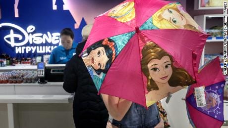A shopper opens an umbrella depicting Disney princesses at the Central Children's Store on Lubyanka Square, Moscow in 2017.