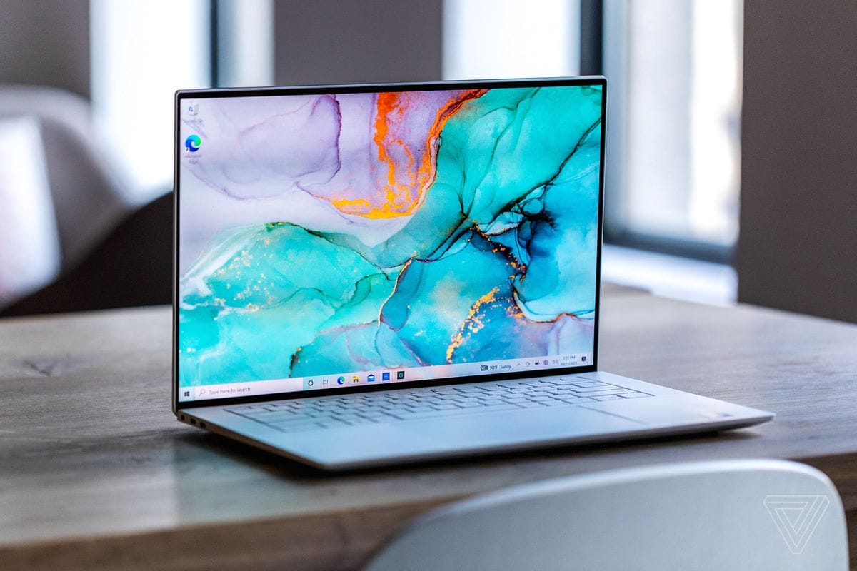 Dell XPS 15 opens on a wooden table.  The screen displays a blue and purple marble surface.